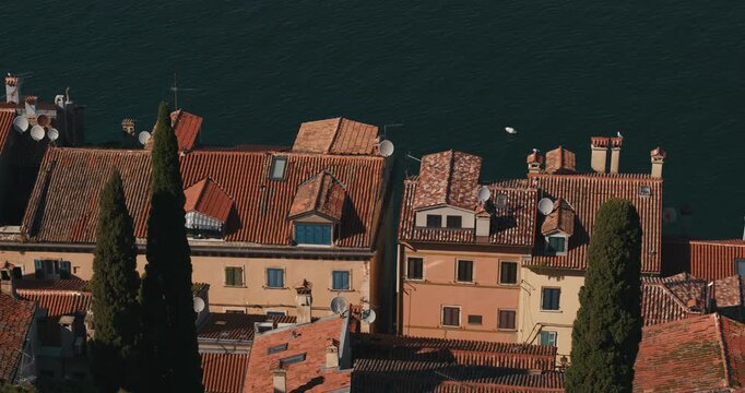 Elevated view of terracotta rooftops and residential buildings beside the Adriatic Sea in Rovinj.