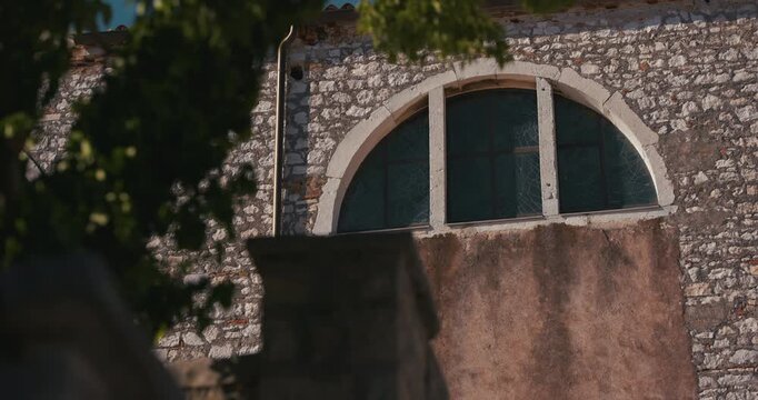 Arched window on the stone facade of the Church of Saint Euphemia in Rovinj old town.