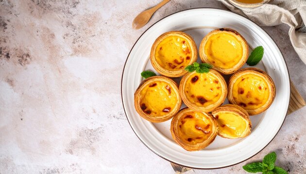 Delicious golden Portuguese egg tarts (Past&eacute;is de Nata) with rich, creamy custard and crisp, flaky pastry, beautifully arranged on a plate, a tempting sweet indulgence
