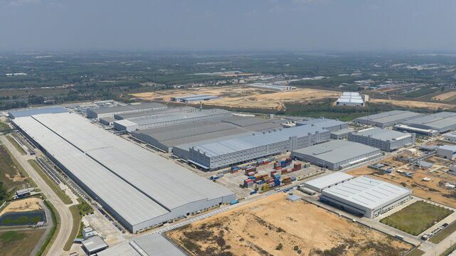 Aerial view of the BYD Thailand Rayong Office Building and industrial complex with large warehouses and shipping containers Phananikhom, Rayong, Thailand.