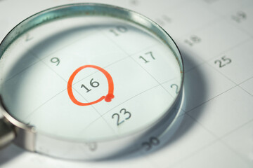 Fototapeta premium Deadline Reminder on Calendar Through Magnifying Glass, Important Date and Time Management Concept.