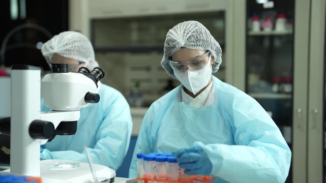 Lab work, scientists holds a test tube takes the test from a test tube in analysis for vaccine development.