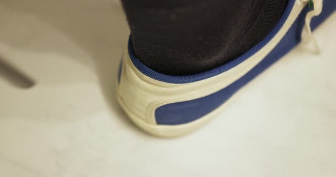 Perspective closer shot of while using a heel puller metal tool with a right shoe before travelling somewhere.