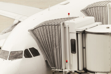 Obraz premium Passenger boarding bridge connected to aircraft at airport terminal
