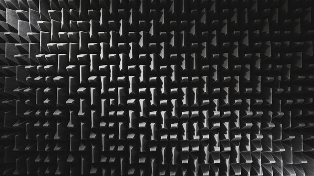Abstract view of dark grey acoustic foam wedge panels creating a geometric soundproofing pattern