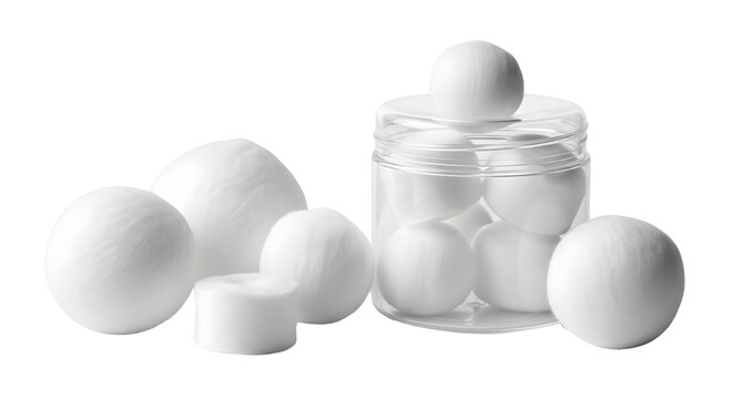 White camphor balls and tablets in a glass jar and scattered on a white background.