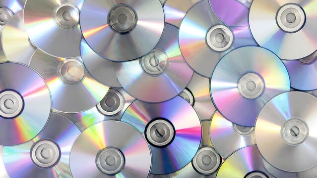 Abstract background composed of many shiny cd CD discs creating a reflective surface with rainbow light patterns