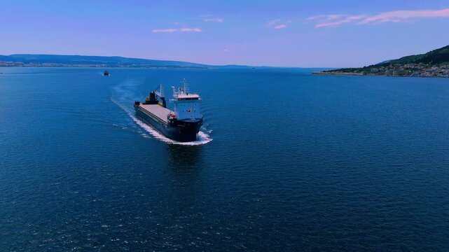 Aerial frontal view of cargo vessel sailing towards camera
