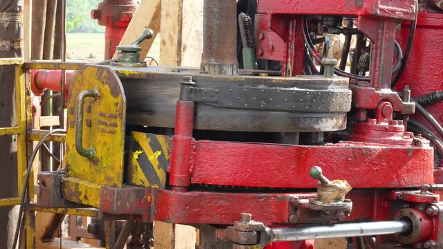 Using power tong, torque machinery, to make connection of the drill pipe in the oil drilling operation. Heavy industrial working scene footage. close-up.