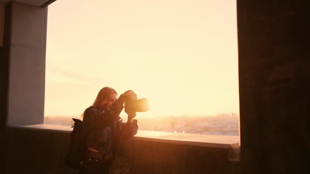 Photographer captures a fashion model with angel wings during a cinematic golden hour rooftop photoshoot with warm sunlight and dreamy atmosphere.