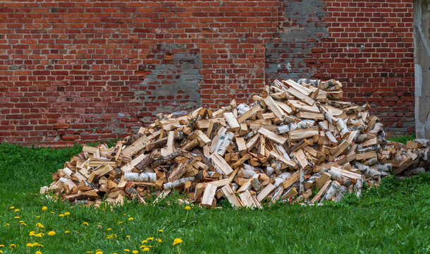 pile of firewood on a brick wall background .