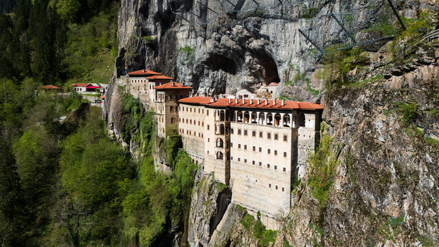 drone perspective of the historic Greek Orthodox Sumela Monastery nestled among dense green pine woods in Trabzon, Turkey