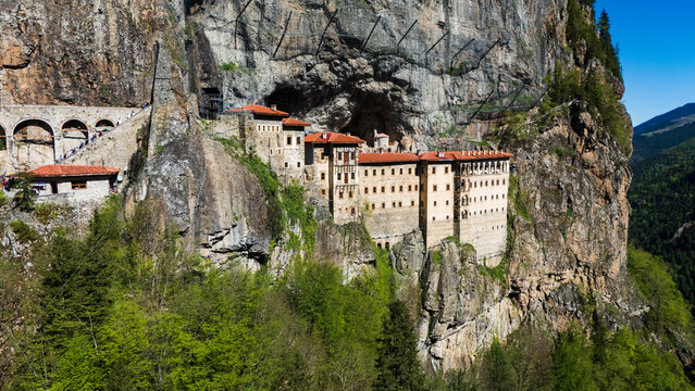 drone perspective of the historic Greek Orthodox Sumela Monastery nestled among dense green pine woods in Trabzon, Turkey
