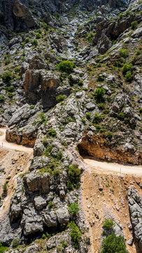 Aerial perspective flying through the deep Dark Canyon in Kemaliye, Turkey. Drone shot following the path of the Karasu River with the legendary hand-carved Stone Road visible on the cliff