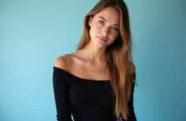 Naklejka premium Young woman with light brown hair wears black off-shoulder top. She poses against soft blue studio background, her direct gaze calm and composed. Attractive person with natural beauty.