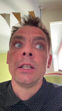 Closeup selfie of caucasian man vlogging in intimate confessional shot in bright living room with bunting, natural window light and dotted shirt sequences show