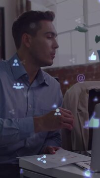 Vertical video: Laptop pinging male pro turning speaking tapping docs marketing icons guiding reply