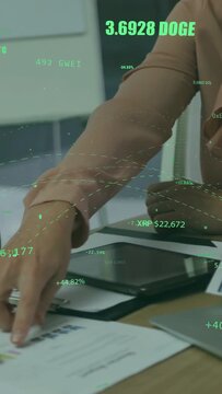 Vertical video: Woman pointing tablet, man tapping charts, AR crypto overlays highlighting trends