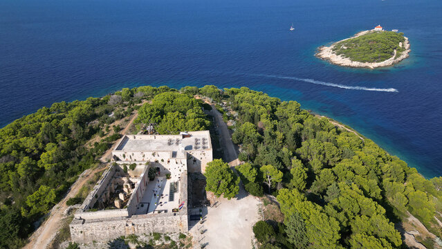 Aerial view of Fort George surrounded by lush pine forests and the deep blue Adriatic Sea in Vis, Splitsko-dalmatinska, Croatia.