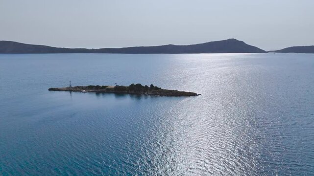 Aerial Drone View of Small Rocky Islet with Navigation Beacon and Sunlit Blue Sea in Navarino Bay near Gialova, Peloponnese, Greece