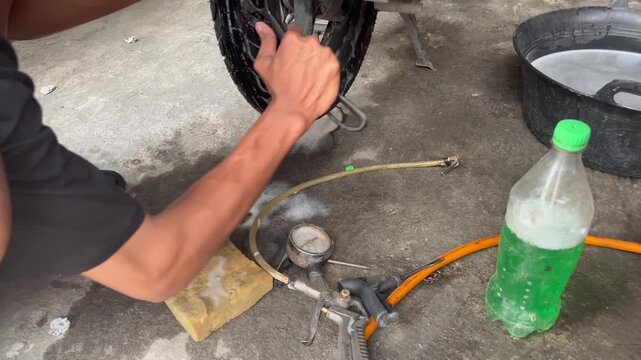 Mechanic Removing Nail From Punctured Tubeless Tire With Pliers
