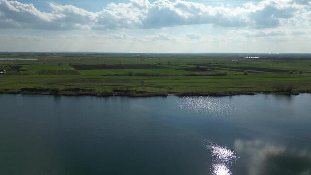 Peskara lake reflecting sky and surrounding farmland