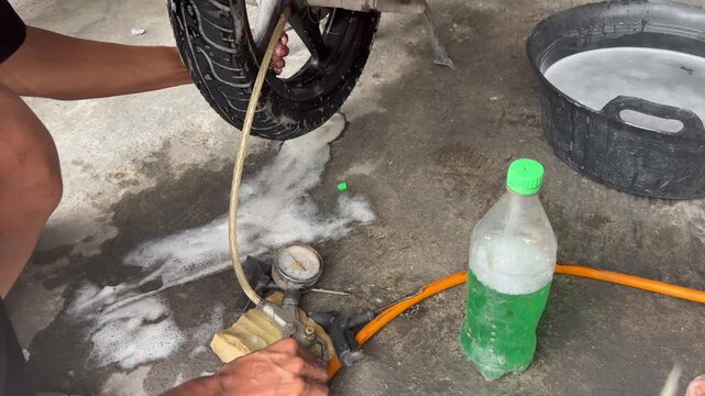 Mechanic Inflating Repaired Tubeless Motorcycle Tire