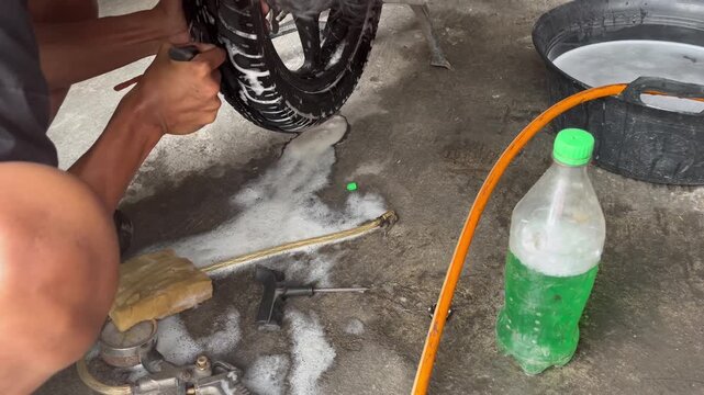 Hand Inserting Tire Repair String into Flat Motorcycle Tyre