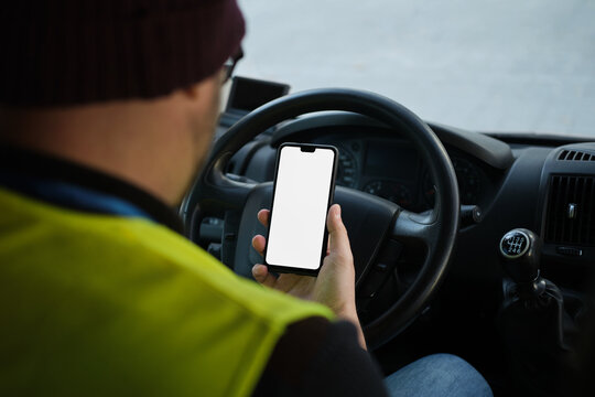 close up of Professional man using smartphone with white screen in van. unrecognizable person