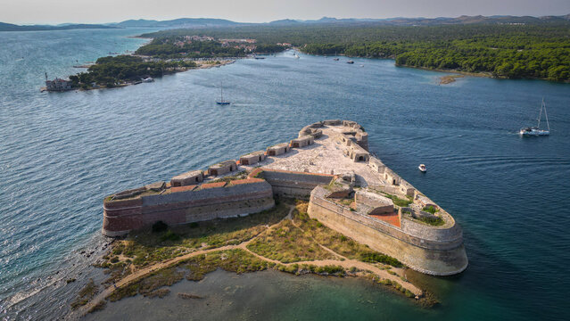 Aerial view of the triangular St. Nicholas Fortress surrounded by the blue waters of the St. Anthony Channel in Sibenik, Croatia.