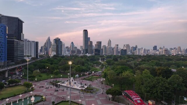 Bangkok, Thailand - April 24 2026: Panoramic footage of sunset over Lumphini park in downtown Bangkok by Silom with BTS track above the busy street in the heart of Thailand capital city