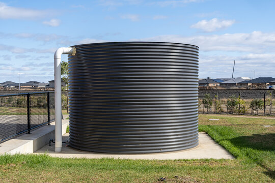 Large corrugated iron rainwater tank installed on a concrete slab in a public park, sustainable water conservation infrastructure for community facility, Melbourne, Australia