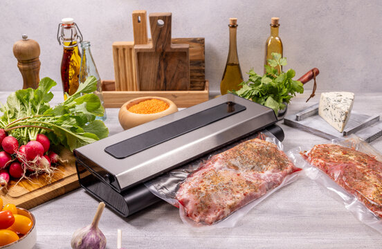 Vacuum sealer preserving meat and fresh ingredients on kitchen counter