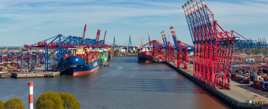 Aerial view of Waltershofer Hafen with large container ships docked under massive gantry cranes and stacks of colorful containers Hamburg, Hamburg, Germany.