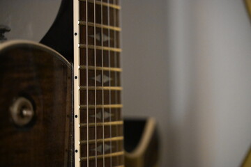 Fototapeta premium Close Up of Guitar Fretboard with Fingers Positioning Chords on Strings