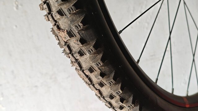 Mountain bicycle tire closeup featuring rugged tread and durable rubber texture. Sport transportation detail suitable for cycling, outdoor, and adventure concepts.