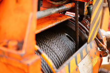 Fototapeta na wymiar An air winch machine on the drilling rig floor, assembly with iron wirerope sling, the equipment using for lifting heavy equipment in the drilling operation. Industrial equipment object, close-up.
