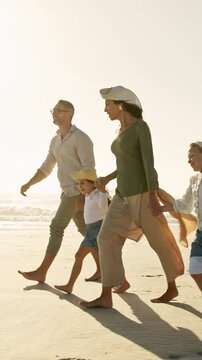 Parents, children and holding hands on beach with walk, smile or bonding together for summer holiday. Happy people, mother and father by ocean with girl kids, family vacation or travel for connection