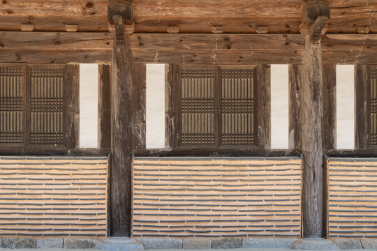 Close-up of traditional Korean wooden windows with lattice pattern and mud wall architecture