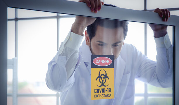 Scientist laboratory window warning danger covid biohazard pandemic safety quarantine Scientist laboratory looking through window covid biohazard
