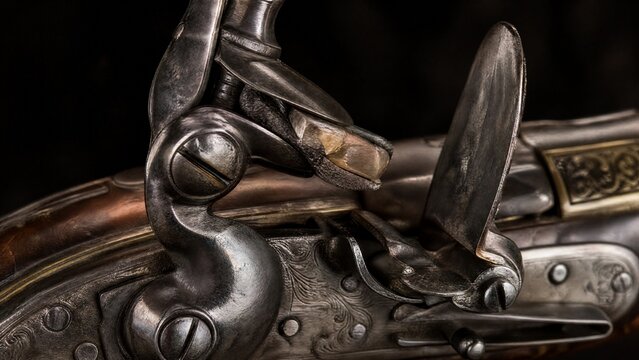 Close-up detail of ornate flintlock pistol focusing on flint against frizzen.