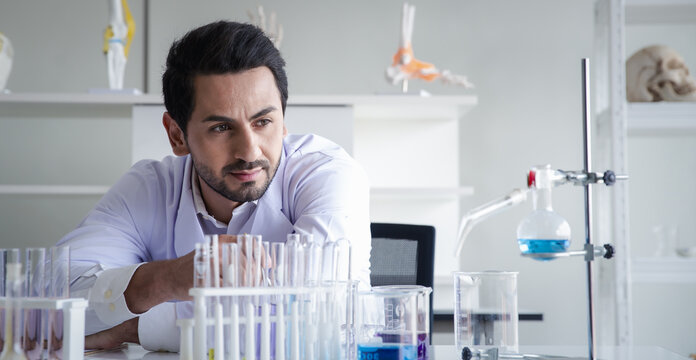 Scientist man laboratory glassware experiment research chemistry analysis focused scientist man laboratory glassware experiment research chemistry