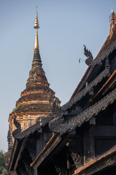 ancient Buddhist temple pagoda with traditional Lanna roof architecture in Thailand, historic Chiang Mai monastery with ornate wooden carvings and sacred stupa, Wat Lok Moli