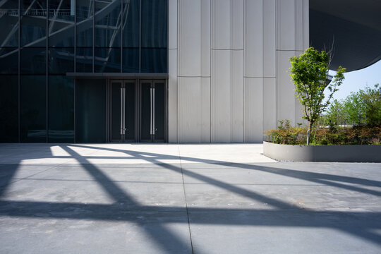 Modern building exterior with glass curtain wall and concrete facade under sunlight