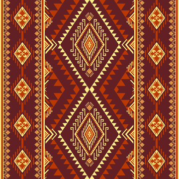 Geometric ethnic vertical border pattern in Ikat tribal style. Traditional luxury maroon and gold fabric textile stripe background for fashion apparel.