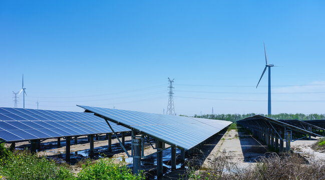 Coastal Renewable Energy Farm Featuring Solar Arrays and Wind Turbines Under Clear Sky