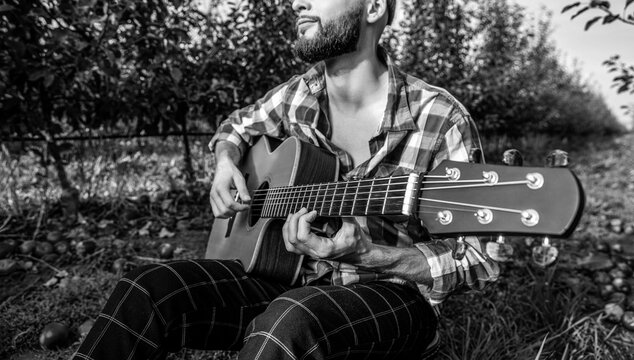Guitars playing. Music concept. Guitars acoustic. Male musician playing guitar, music instrument. Black and white