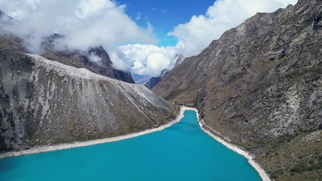 Huaraz, Peru: Footage of famous laguna paron in Caraz, Huaraz region, Peru. Surrounded by mountain range and with cloudy dramatic sky, showing cordillera blanca in the background. Taken with forward a