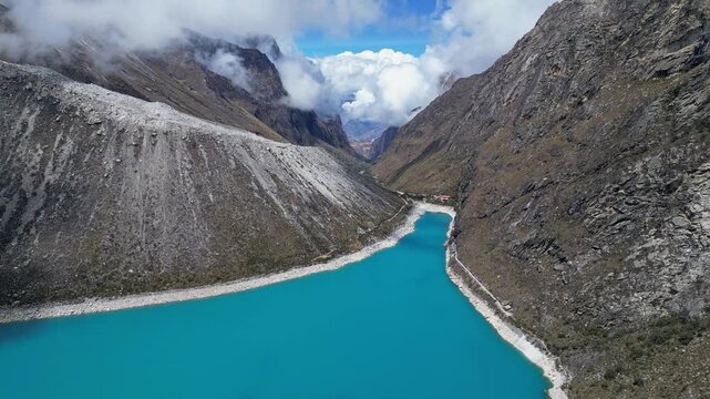Huaraz, Peru: Footage of famous laguna paron in Caraz, Huaraz region, Peru. Surrounded by mountain range and with cloudy dramatic sky, showing cordillera blanca in the background. Taken with forward a