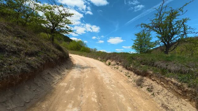 Sunlit dirt path winds through green hills. Bigar Waterfall, Stara Planina. (Balkan Mountains), Serbia.